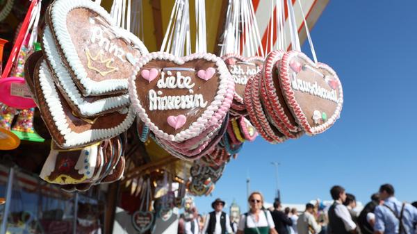 Besucher gehen beim Start des Oktoberfestes an einem Stand mit Lebkuchenherzen vorbei. Die 191. Wiesn findet vom 19. September bis zum 4. Oktober 2026 auf der Münchner Theresienwiese statt.