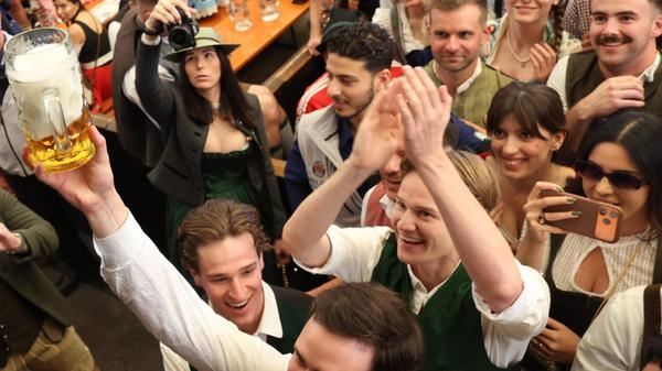 Im Paulaner Festzelt werden zum Start des Oktoberfestes die ersten Biere an Besucher verteilt. Es werden in den kommenden Wochen wieder rund 6,5 bis 7 Millionen Gäste aus dem In- und Ausland erwartet.