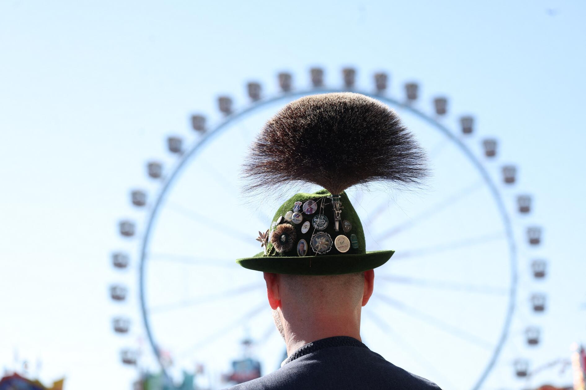 Ein Trachtler mit Gamsbart steht beim Start des Oktoberfestes nach dem Einlass auf der Festwiese vor dem Riesenrad. Tracht ist auf dem Mega-Event nicht wegzudenken. 