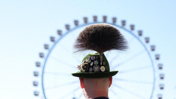 Ein Trachtler mit Gamsbart steht beim Start des Oktoberfestes nach dem Einlass auf der Festwiese vor dem Riesenrad. Tracht ist auf dem Mega-Event nicht wegzudenken.