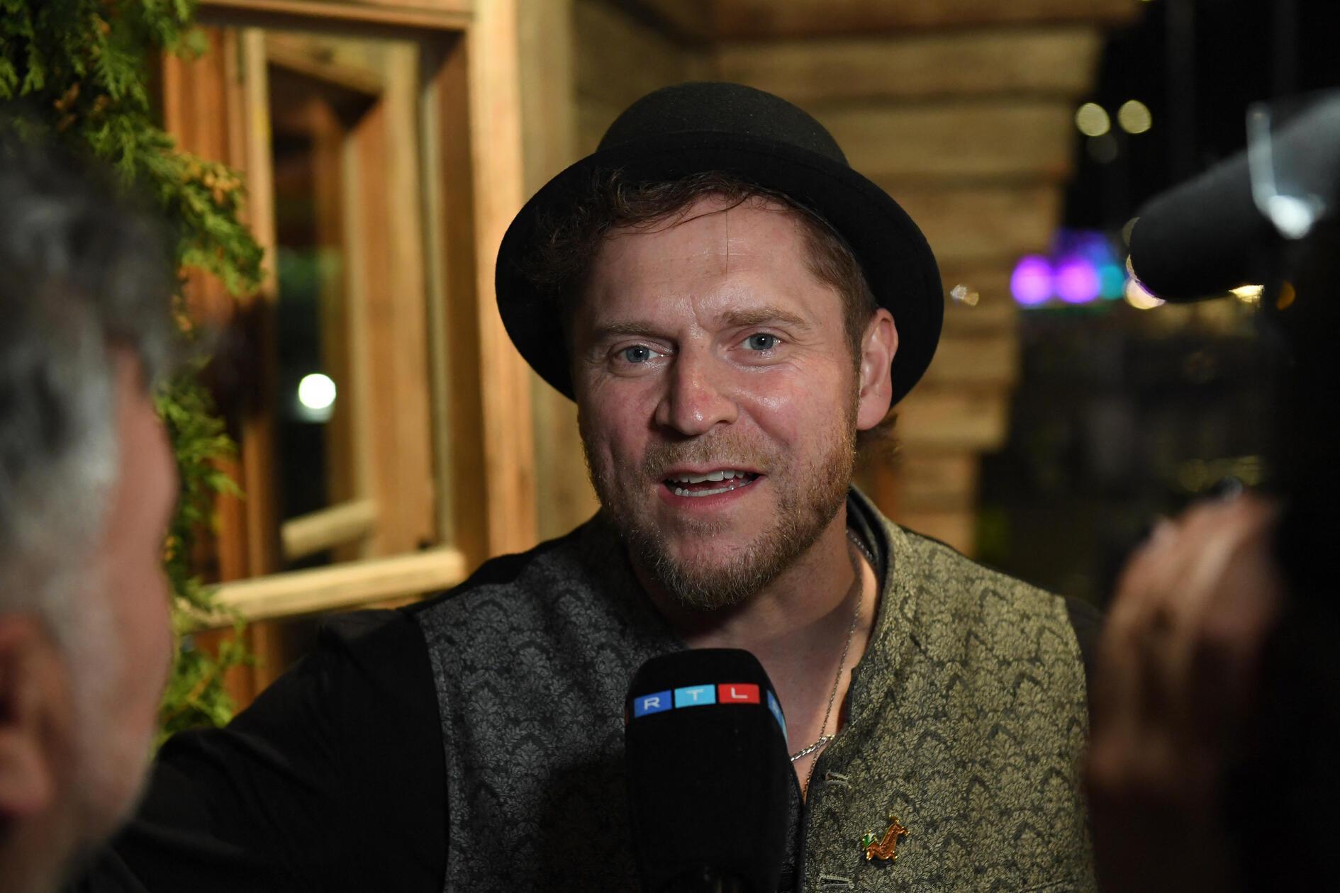 Der Musiker Johannes Oerding wird beim Almauftrieb im Käferzelt interviewt.