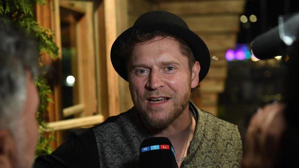 Der Musiker Johannes Oerding wird beim Almauftrieb im Käferzelt interviewt.