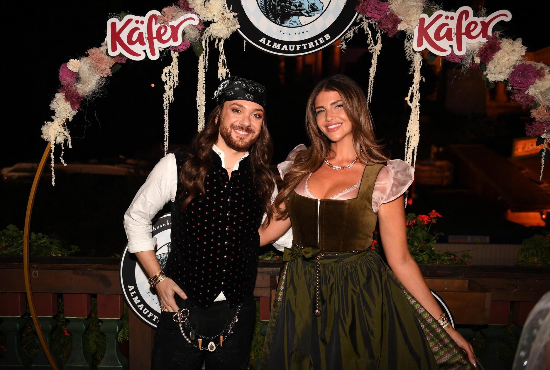 Der Moderator Riccardo Simonetti und Farina Opoku zeigen sich beim Almauftrieb im Käferzelt in München.