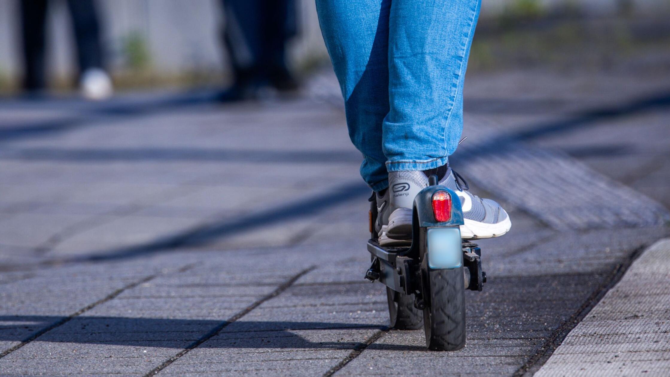 Ein Mann fährt mit seinem E-Scooter über den Bahns