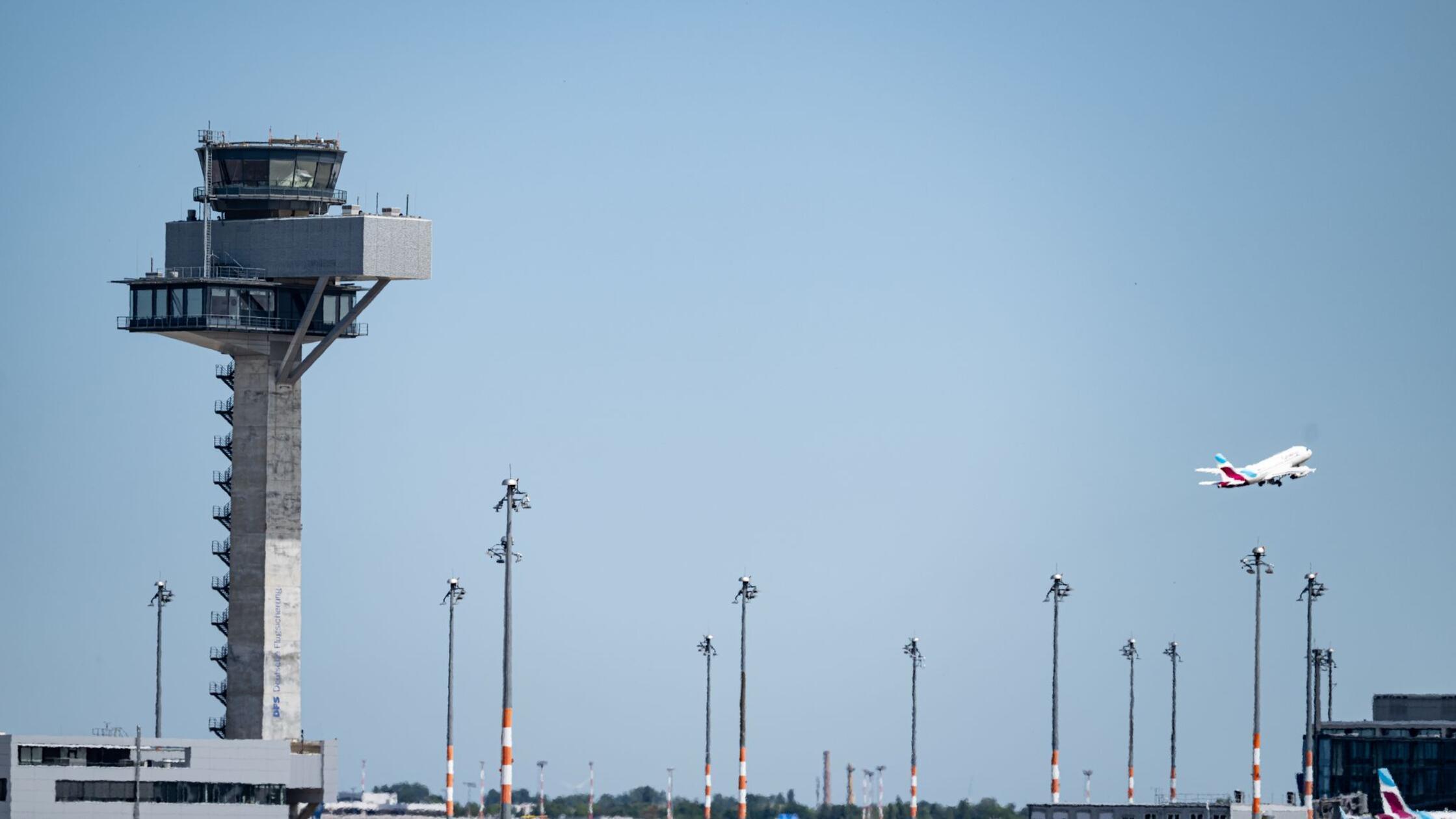 Ein Flugzeug fliegt am Tower des Flughafen Berlin 