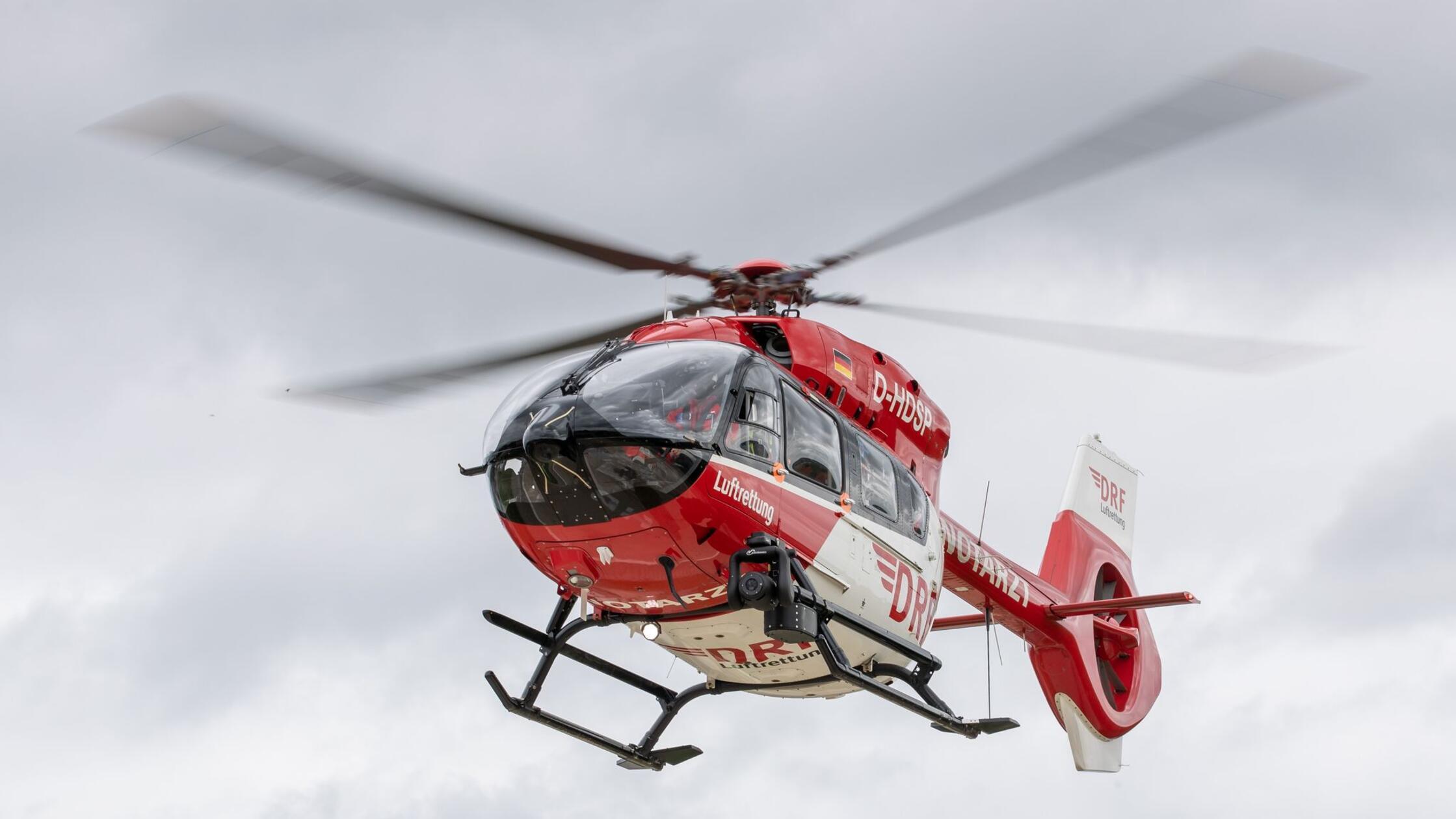 Ein Rettungshubschrauber fliegt einen Einsatz. (zu