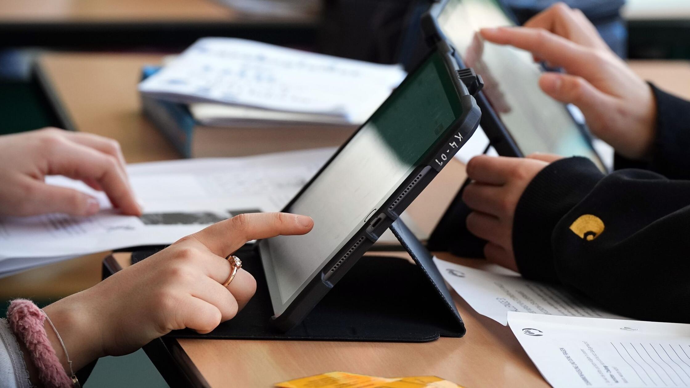 Schüler lösen im Unterricht an Tablets eine Aufgab