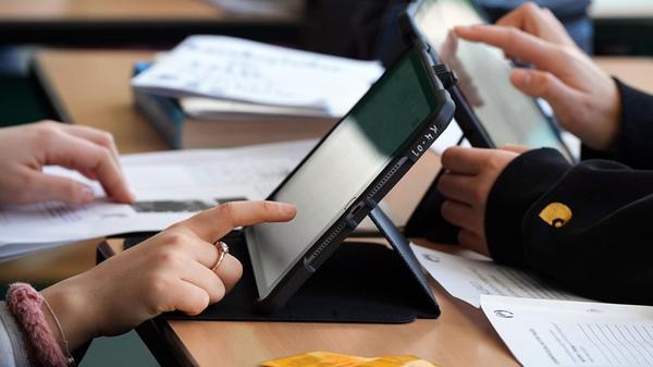 Schüler lösen im Unterricht an Tablets eine Aufgab