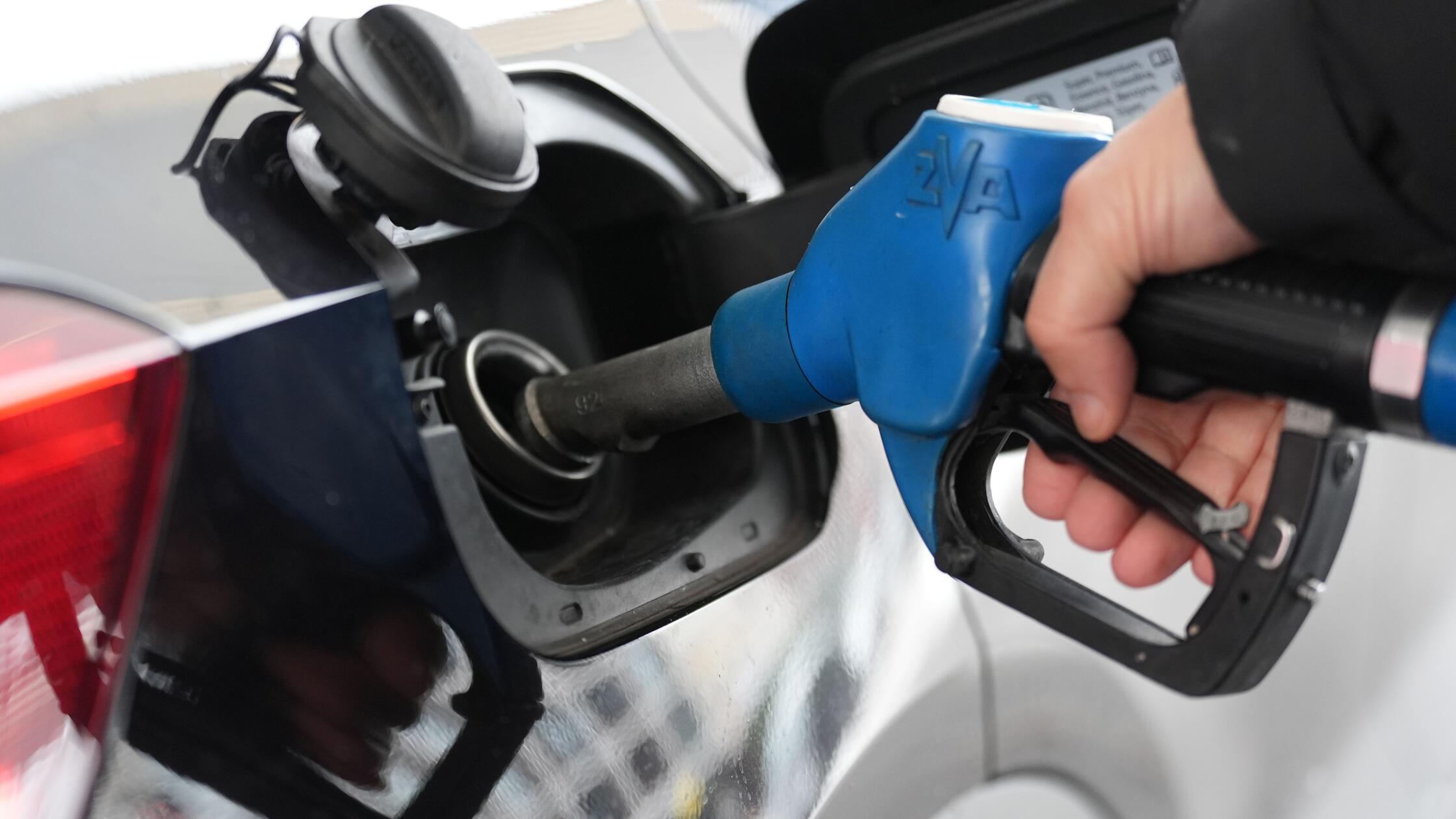 Ein Mann tankt an einer Tankstelle ein Auto. (zu d