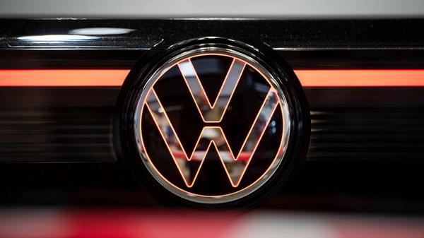 Blick auf ein beleuchtetes VW-Logo am Heck eines F