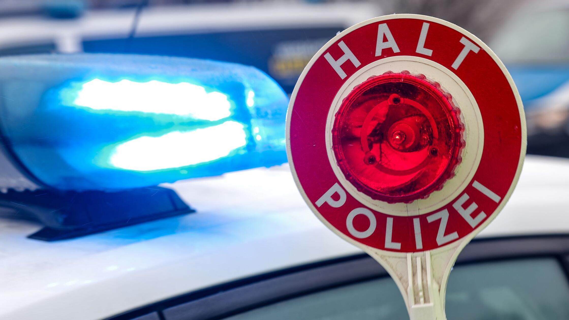 Ein Polizist hält eine Polizeikelle für eine Kontr