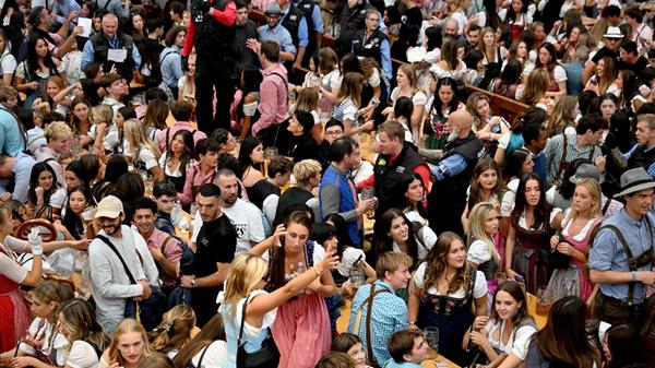 Besucher der Wiesn feiern im Hofbräu Festzelt auf