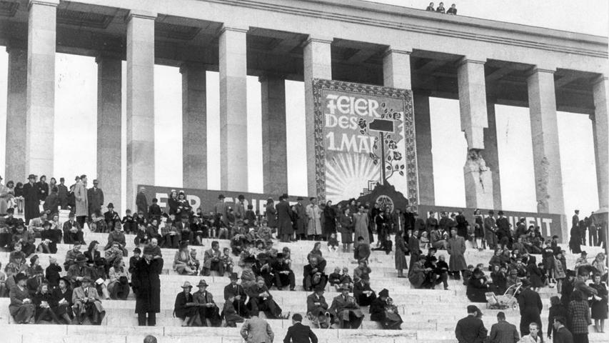 Das Zeppelinfeld bleibt ein Platz für Aufmärsche und Kundgebungen. Zum "Tag der Arbeit"  1946 und 1947 (unser Foto). sitzen die Menschen auf den Stufen der Säulenhallen ...