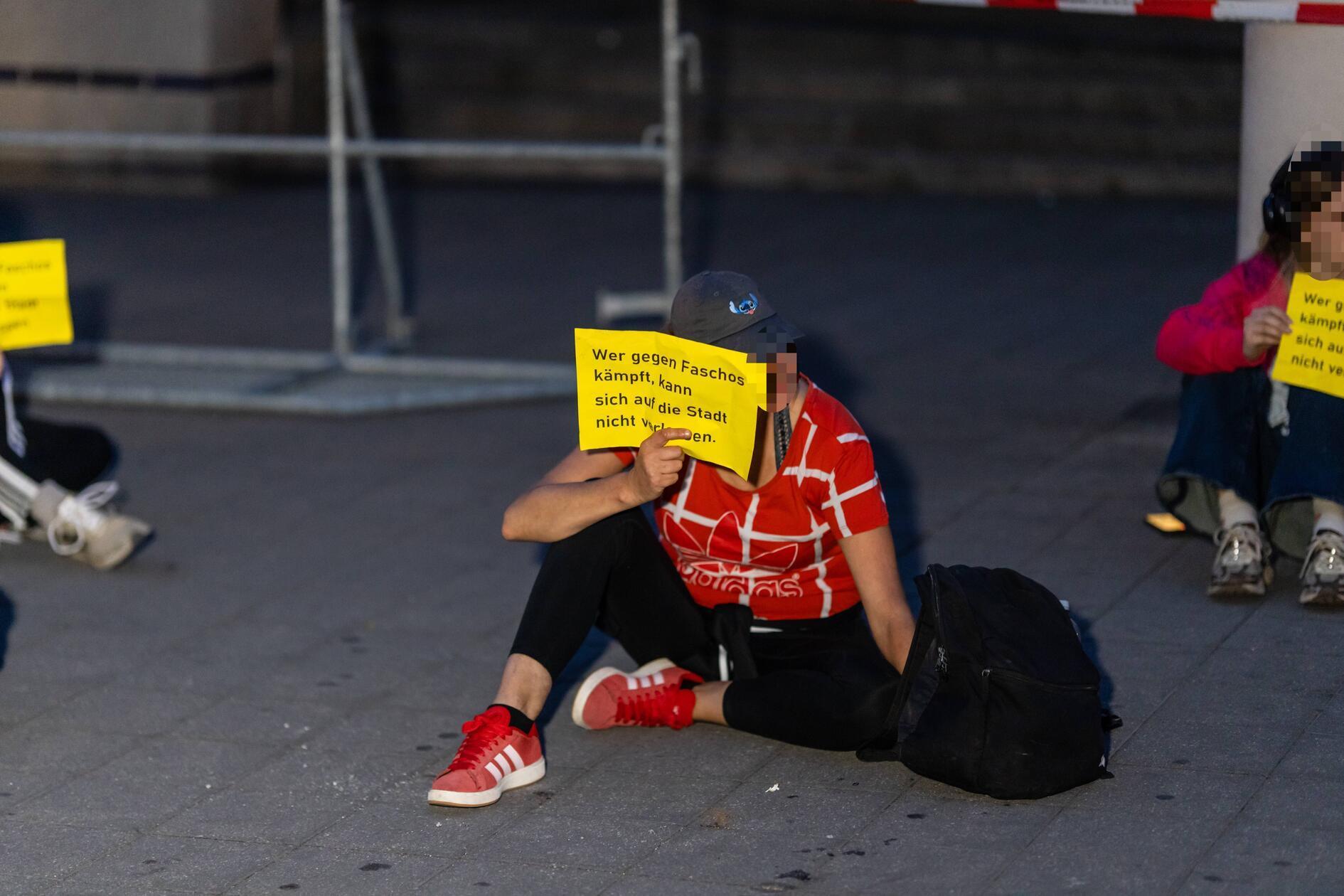 Nach Angaben der Polizei Mittelfranken ließen sich bereits gegen 16.45 vier Personen der Gegendemonstration in der Kartäusergasse - der Straße der Menschenrechte - nieder und klebten sich mit den Händen am Boden fest. 