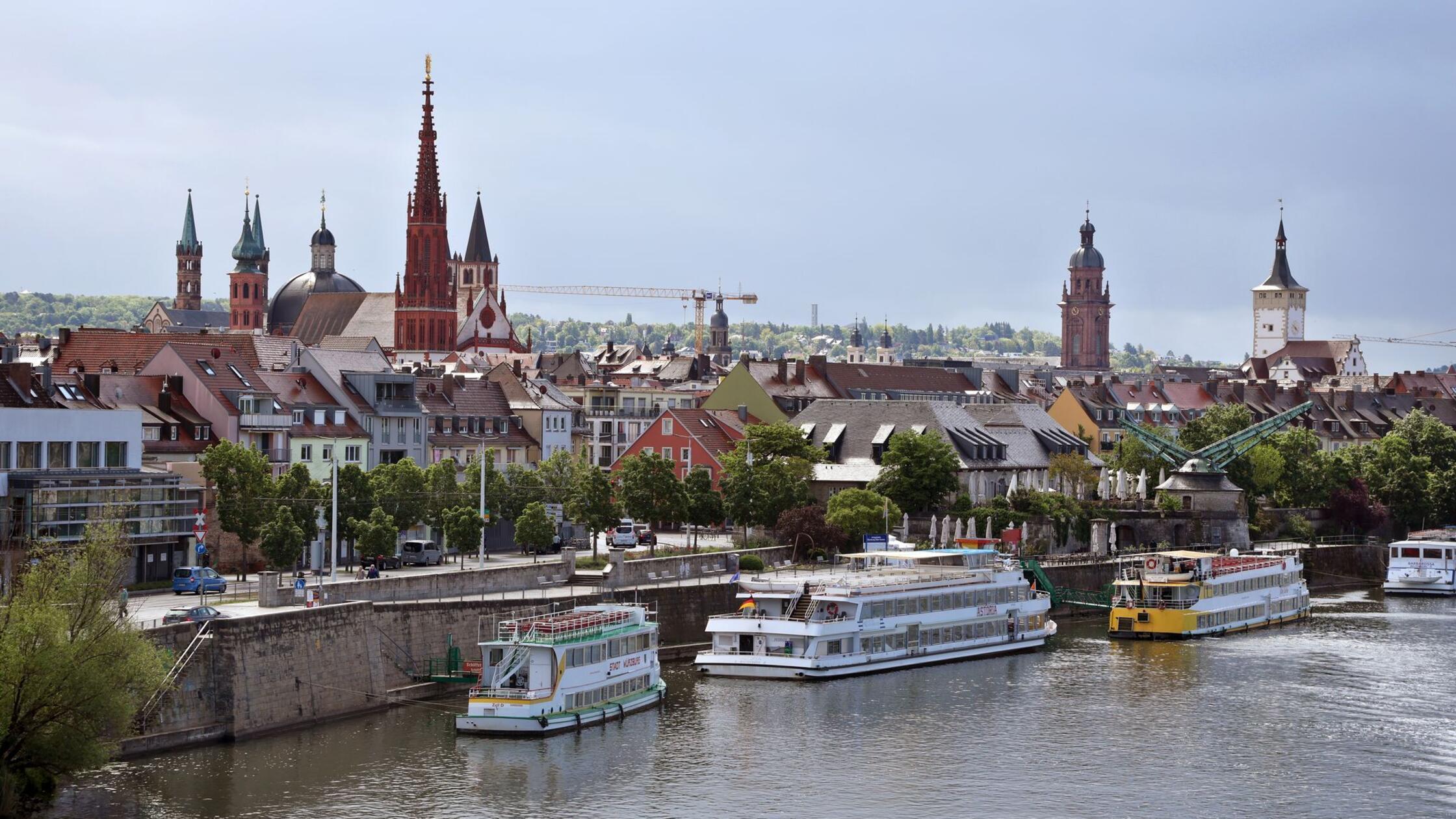 Ausflugsschiffe liegen vor Kirchtürmen und dem Rat