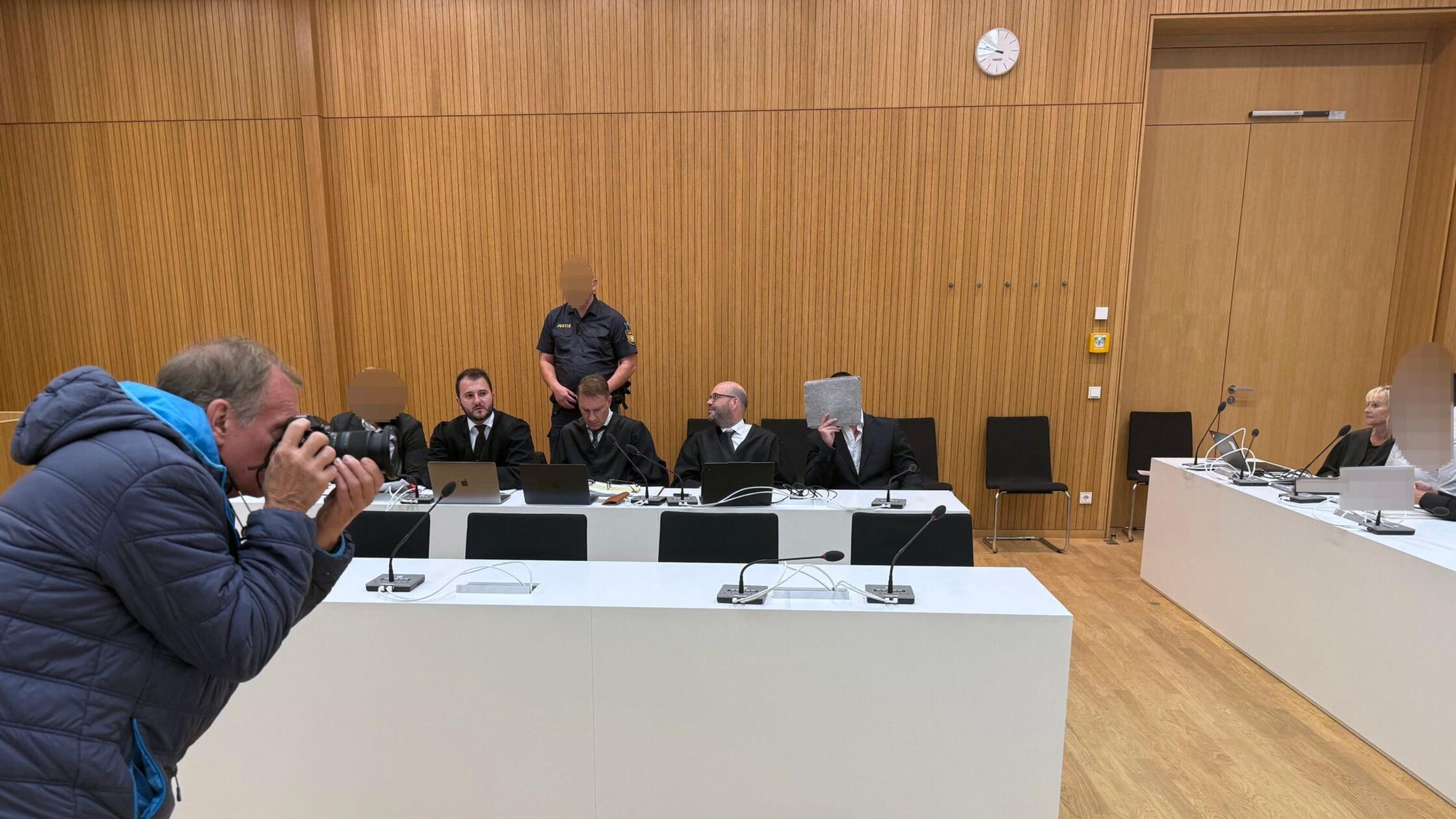 Drei der Angeklagten (2.vl, M, r) sitzen in einem 