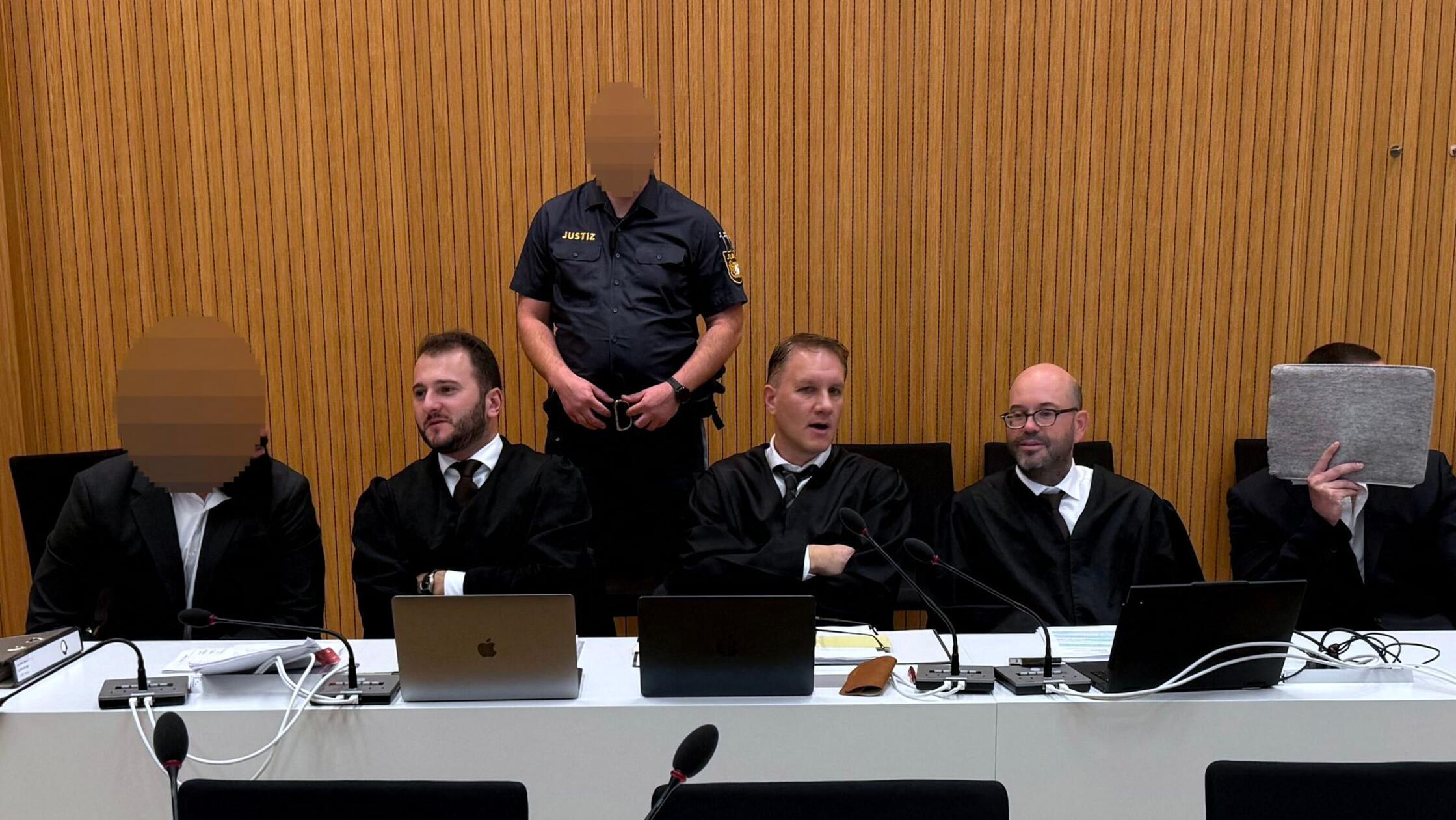 Zwei der Angeklagten (l u. r) sitzen in einem Geri