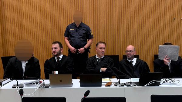 Zwei der Angeklagten (l u. r) sitzen in einem Geri