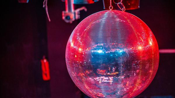 Die farbig beleuchtete Discokugel dreht sich über