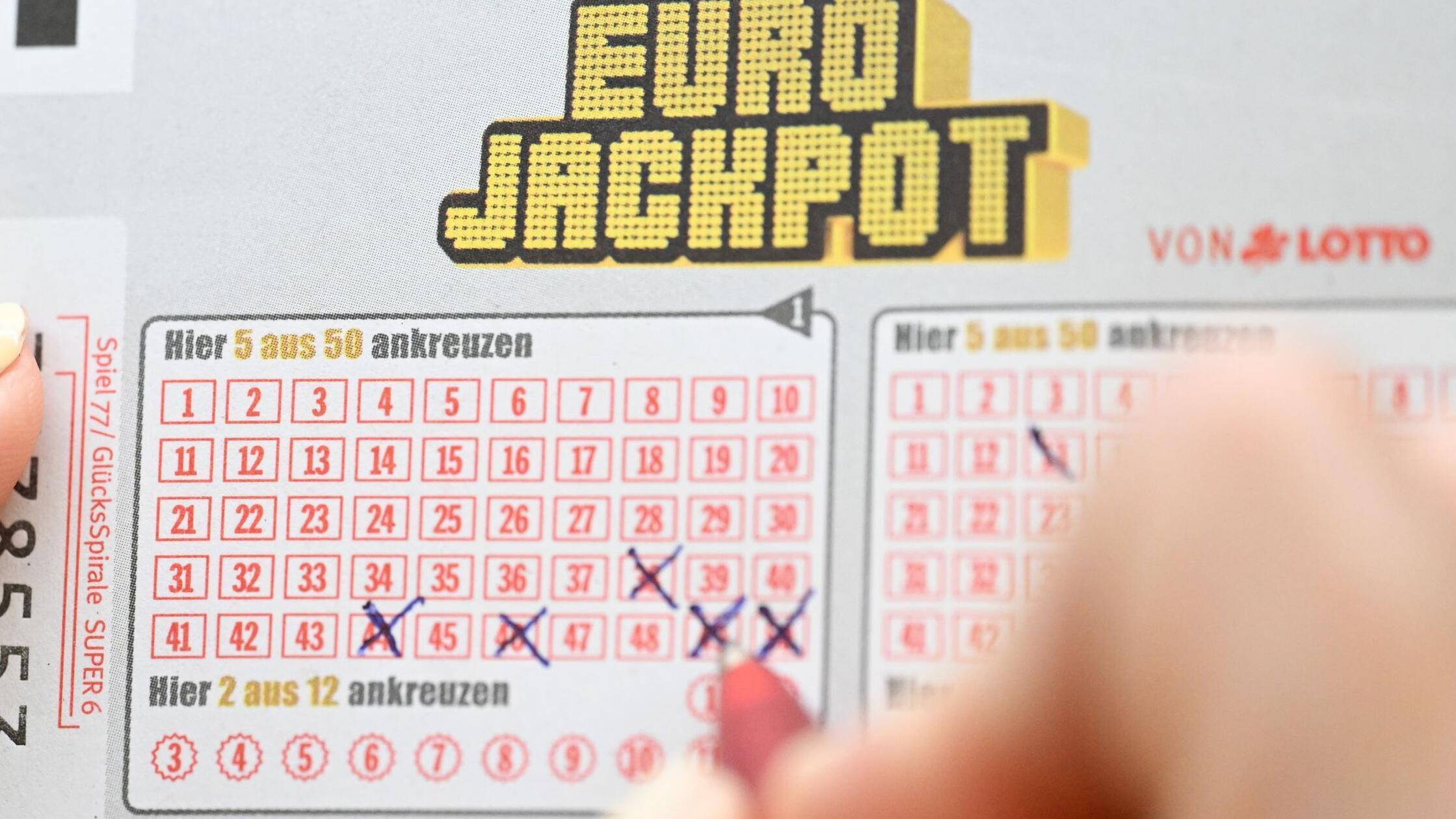 Eine Person füllt einen Eurojackpot-Schein aus (ge