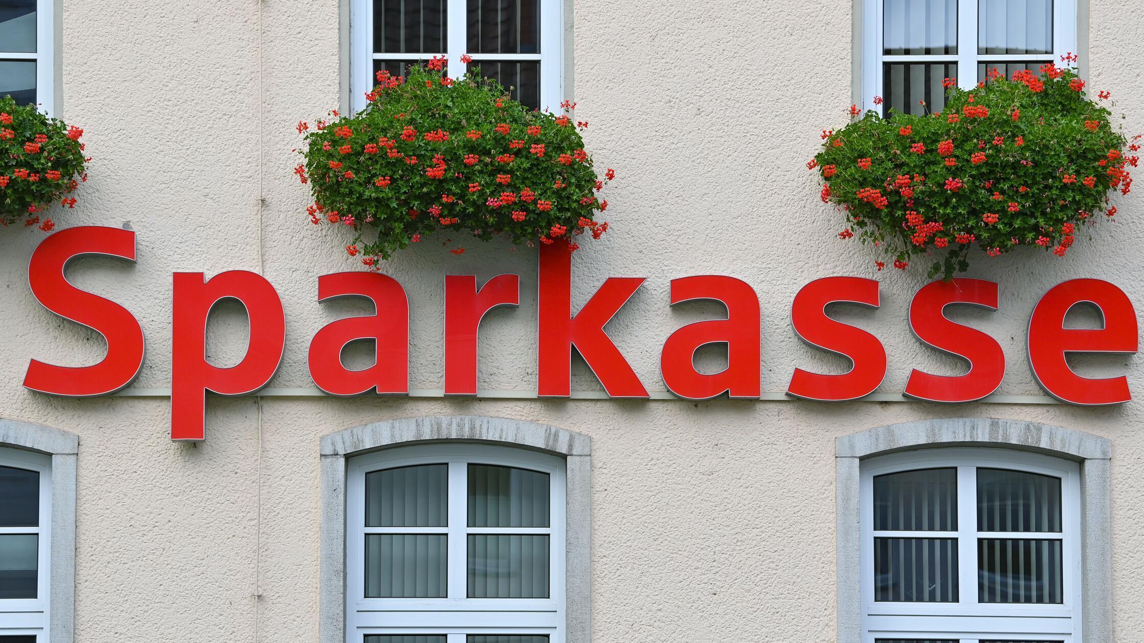 Der Schriftzug «Sparkasse» hängt an einer Fassade.