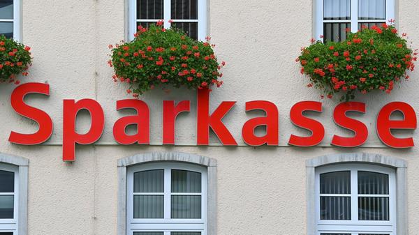 Der Schriftzug «Sparkasse» hängt an einer Fassade.