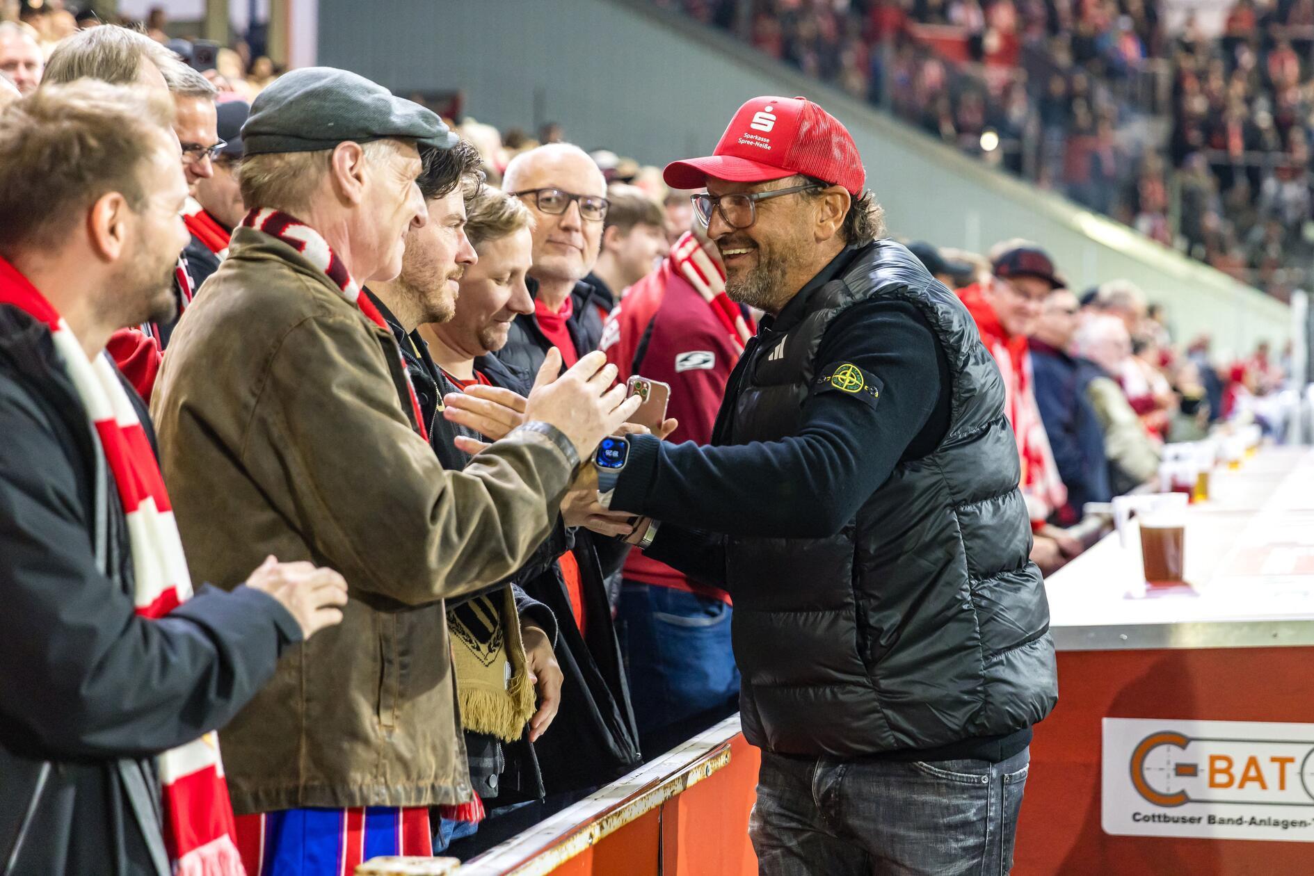 16.10.2026, Brandenburg, Cottbus: Fußball, Männer: 2. Bundesliga, Energie Cottbus - 1. FC Nürnberg, 8. Spieltag, LEAG Energie Stadion. Trainer Claus-Dieter Wollitz (FC Energie Cottbus) begrüßt Besucher. Foto: Frank Hammerschmidt/dpa +++ dpa-Bildfunk +++