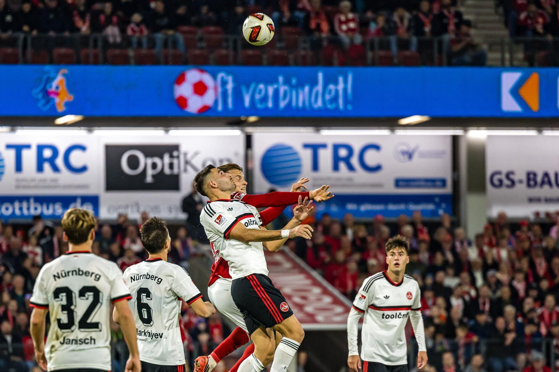 16.10.2026, Brandenburg, Cottbus: Fußball, Männer: 2. Bundesliga, Energie Cottbus - 1. FC Nürnberg, 8. Spieltag, LEAG Energie Stadion. Alexios Kalogeropoulos (1. FC Nürnberg) und Moritz Hannemann (FC Energie Cottbus) sind zum Kopfball in der Luft. Foto: Frank Hammerschmidt/dpa +++ dpa-Bildfunk +++