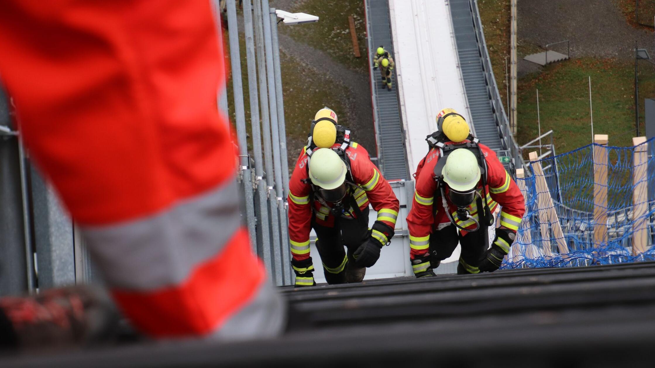 Feuerwehrleute steigen in voller Bandschutzmontur 