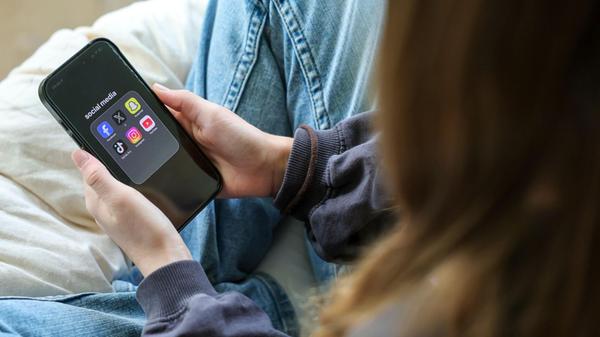 Ein Mädchen hält ein iPhone 16 in den Händen, auf