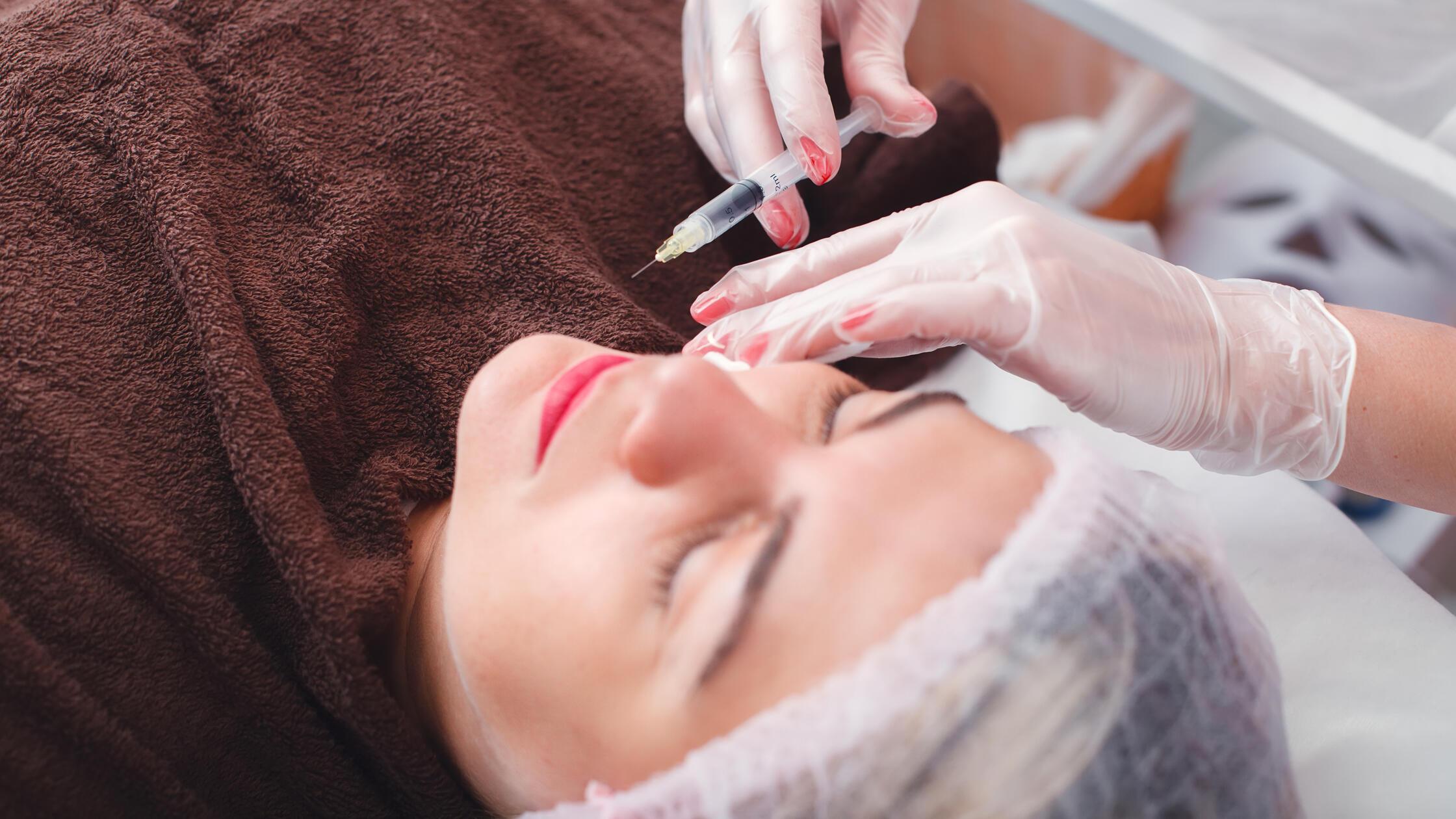 Injection syringe in the woman s face. model relea