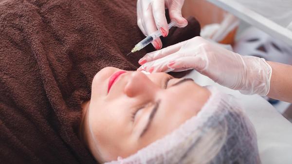 Injection syringe in the woman s face. model relea