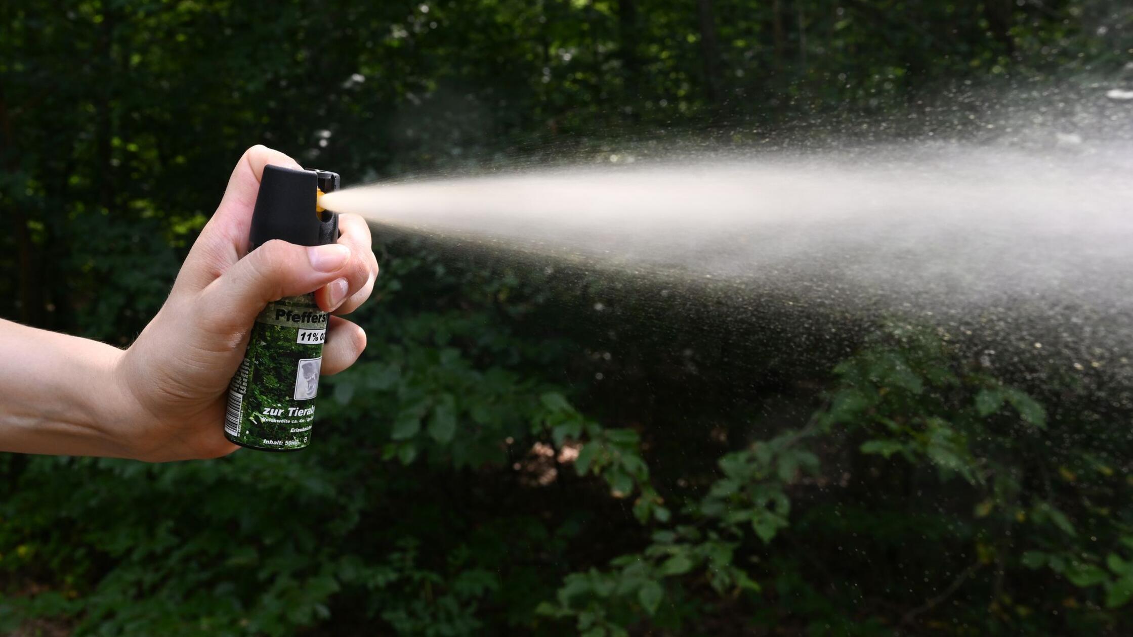 Eine Hand hält eine Kartusche mit Pfefferspray und