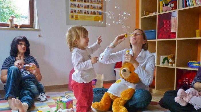 Die kleine Katharina (Zweite von links) ist mit 19 Monaten ein alter Hase in der Zwergensprache: Sie hat mit ihrer Mama schon zwei Kurse besucht. Nachdem sie mit Worten und Gesten klar gemacht hat, dass sie mehr Seifenblasen möchte, pustet Kursleiterin Bettina Behringer noch einmal in den gelben Plastikring. Die kleine Katharina (Zweite von links) ist mit 19 Monaten ein alter Hase in der Zwergensprache: Sie hat mit ihrer Mama schon zwei Kurse besucht. Nachdem sie mit Worten und Gesten klar gemacht hat, dass sie mehr Seifenblasen möchte, pustet Kursleiterin Bettina Behringer noch einmal in den gelben Plastikring.