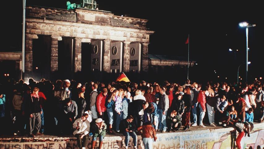 In der DDR erwächst offener Protest gegen das SED-Regime. Die Ausreisewilligen besetzen die bundesdeutschen Botschaften, im ganzen Land gehen die Menschen auf die Straße, am 9. November fällt die Mauer. Der als "Aussitzer" geschmähte Kohl zeigt sich in dieser Situation entschlossen.