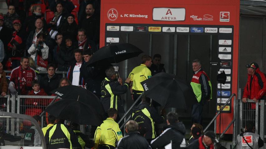 Schiri Dingert musste im Schutze von schwarzen Regenschirmen vom Platz geleitet werden.