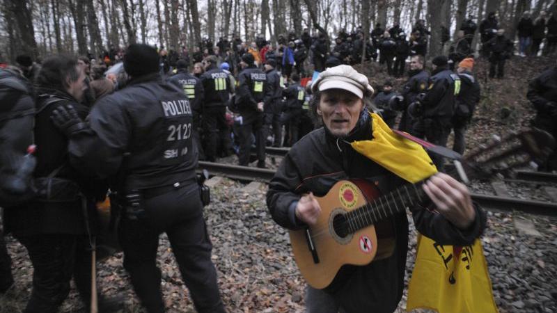 Während ein friedlicher Demonstrant Gitarre spielte, gingen die Polizisten im Hintergrund gegen die "Steinewerfer", beziehungsweise sogenannten "Schotterer" vor.
