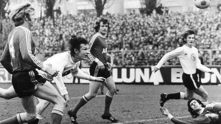 Der 27. Spieltag der 2. Liga Süd in der Saison 1974/75 bedeutete einen Feiertag für den Fürther Schatzmeister. Erstmals in der Vereinsgeschichte nahm man am Ronhof bei einem Spiel mehr als 100.000 Mark ein - exakt waren es 127.000. Sportlich lief es - zumindest, wenn man das Resultat betrachtet - ebenfalls gut für das Kleeblatt, das den Club mit 3:2 (auf unserem Bild köpft Bopp das Tor zum 2:1) in die Schranken wies. Ein wichtiger Erfolg auf dem Weg zum späteren Klassenverbleib. Auf Nürnberger Seite war man hingegen stinksauer... Der 27. Spieltag der 2. Liga Süd in der Saison 1974/75 bedeutete einen Feiertag für den Fürther Schatzmeister. Erstmals in der Vereinsgeschichte nahm man am Ronhof bei einem Spiel mehr als 100.000 Mark ein - exakt waren es 127.000. Sportlich lief es - zumindest, wenn man das Resultat betrachtet - ebenfalls gut für das Kleeblatt, das den Club mit 3:2 (auf unserem Bild köpft Bopp das Tor zum 2:1) in die Schranken wies. Ein wichtiger Erfolg auf dem Weg zum späteren Klassenverbleib. Auf Nürnberger Seite war man hingegen stinksauer...