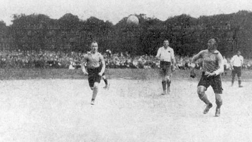 Vor knapp 120 Jahren, im Herbst 1902, standen sich der Club und Fürth (damals noch als TV 1860) zum ersten Mal gegenüber. Am Schießanger feierte der FCN einen 15:0-Kantersieg. Doch das Kräfteverhältnis sollte so klar nicht bleiben. 1910, beim ersten Spiel, das am Sportplatz am Ronhofer Weg ausgetragen wurde, behielt das Kleeblatt erstmals die Oberhand. Fürth hatte fortan die Vormachtstellung in Fußballfranken, gewann 1914 noch vor dem Club seine erste Meisterschaft. Die Wende stellte das Jahr 1920 dar, als die fränkischen Rivalen im Finale um die Deutsche Meisterschaft (Bild) an den Sandhöfer Wiesen in Frankfurt den nationalen Champion ermittelten. Der Club schlug den Titelverteidiger (wegen des 1. Weltkriegs wurden zwischen 1915 und 1919 keine Meisterschaften ausgespielt) vor der Rekordkulisse von 35.000 Zuschauern durch Tore von Popp und Szabó mit 2:0 und legte den Grundstein für die "goldenen 20er". Vor knapp 120 Jahren, im Herbst 1902, standen sich der Club und Fürth (damals noch als TV 1860) zum ersten Mal gegenüber. Am Schießanger feierte der FCN einen 15:0-Kantersieg. Doch das Kräfteverhältnis sollte so klar nicht bleiben. 1910, beim ersten Spiel, das am Sportplatz am Ronhofer Weg ausgetragen wurde, behielt das Kleeblatt erstmals die Oberhand. Fürth hatte fortan die Vormachtstellung in Fußballfranken, gewann 1914 noch vor dem Club seine erste Meisterschaft. Die Wende stellte das Jahr 1920 dar, als die fränkischen Rivalen im Finale um die Deutsche Meisterschaft (Bild) an den Sandhöfer Wiesen in Frankfurt den nationalen Champion ermittelten. Der Club schlug den Titelverteidiger (wegen des 1. Weltkriegs wurden zwischen 1915 und 1919 keine Meisterschaften ausgespielt) vor der Rekordkulisse von 35.000 Zuschauern durch Tore von Popp und Szabó mit 2:0 und legte den Grundstein für die "goldenen 20er".