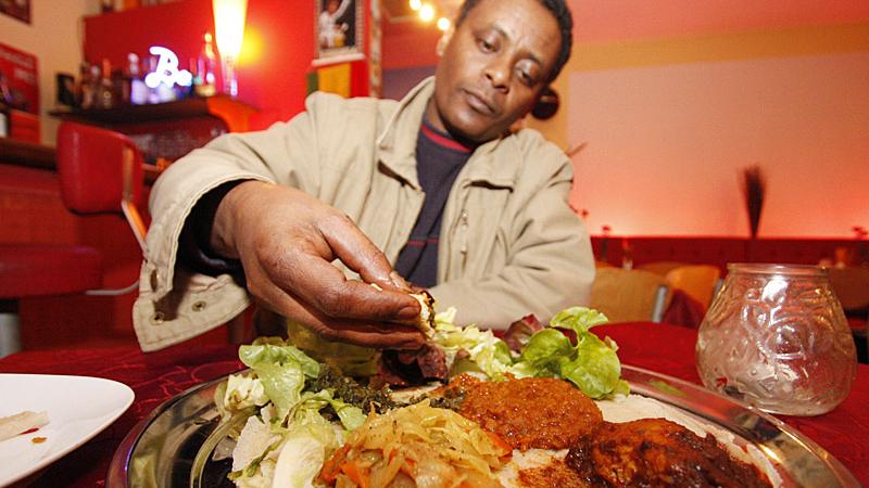 Zu den traditionellen äthiopischen Gerichten wird das weiche Fladenbrot Inschera gereicht. Gegessen wird mit der Hand.
