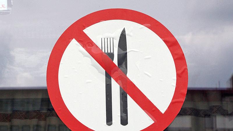 Ein Schild an der Tür weist darauf hin, dass es zwar Speisen gibt, diese aber ohne Besteck verzehrt werden müssen.