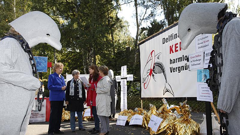 Am Rande des Richtfests demonstrieren Tierschützer vor dem Haupttor gegen die Delfinlagune und kritisieren die Haltung der Meeressäuger im Nürnberger Tiergarten.