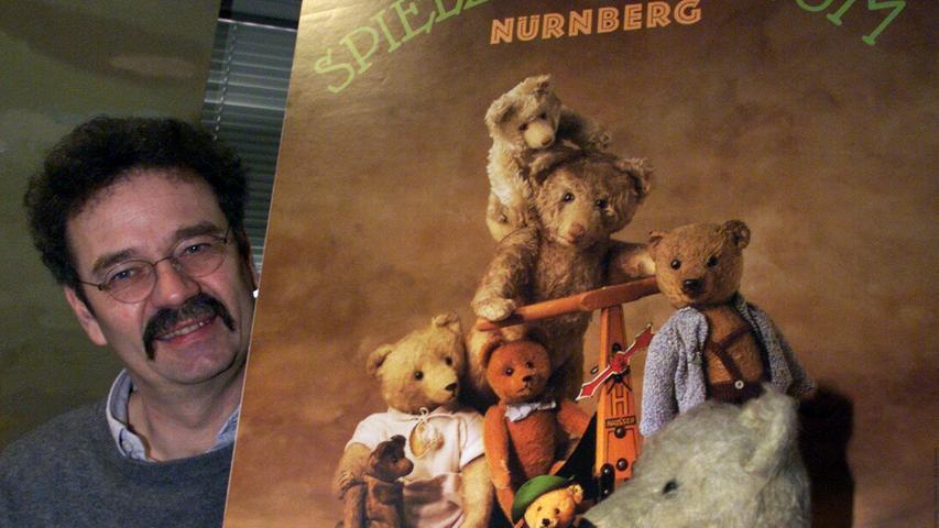 Dr. Helmut Schwarz, Leiter des Spielzeugmuseums, präsentiert das Jahresplakat 2000 mit Teddybären aus den Jahren 1910 bis 1960.