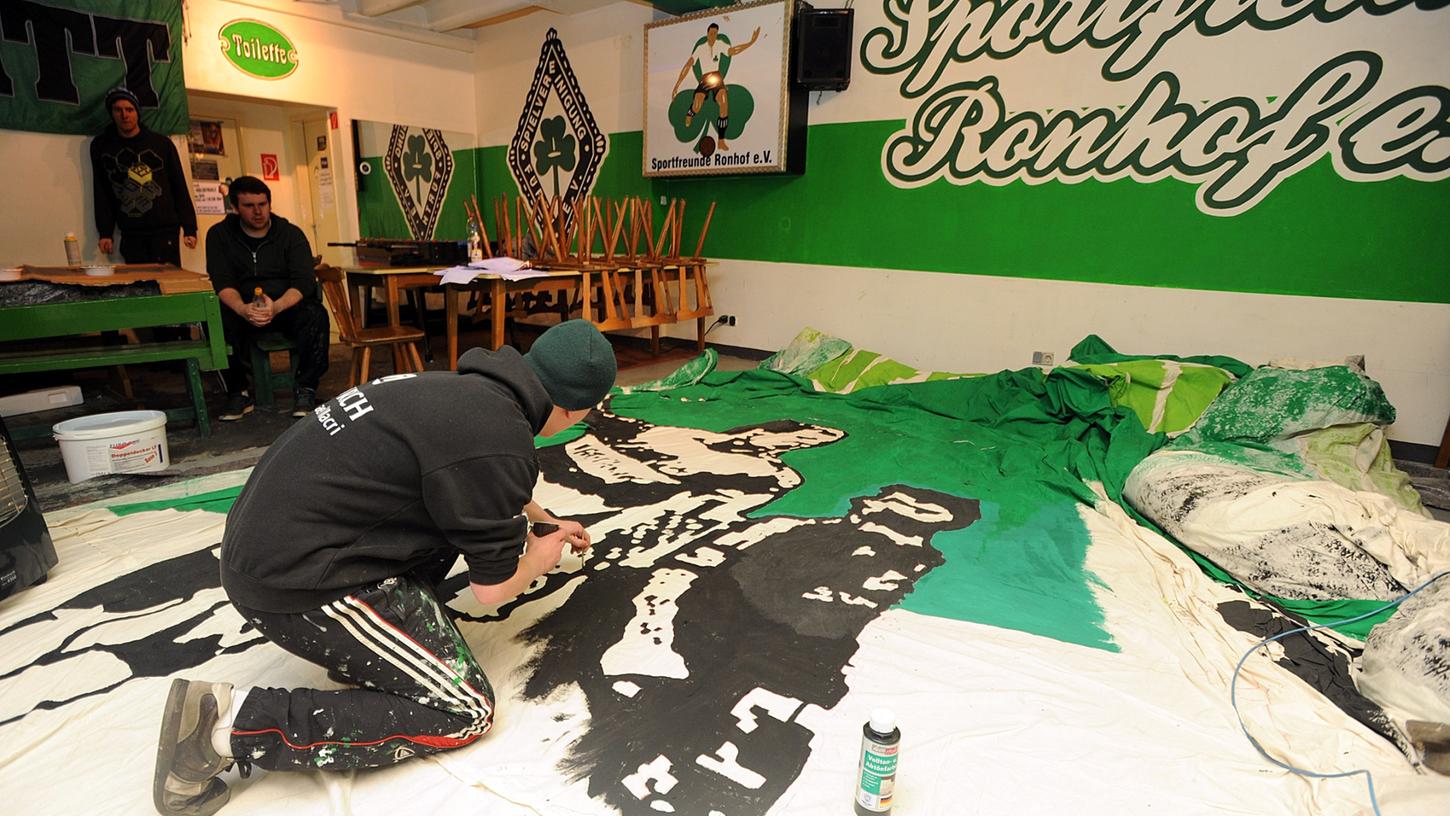 Ein Mitglied der Horidos malt auf einer riesigen Leinwand. In der  neuen Saison können die Fürther Ultras ihre Choreos im Fanprojekt entwerfen.