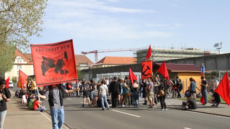 Mit Plakaten und Fahnen marschierte der Solidaritätszug vor das JVA-Gebäude.