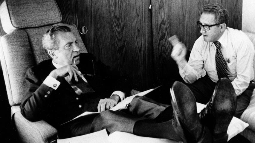 ... er 1973 unter Nixon Außenminister der Vereinigten Staaten von Amerika wird. Hier ist Kissinger mit Richard Nixon im intensiven Gespräch während eines Fluges 1974 zu sehen.