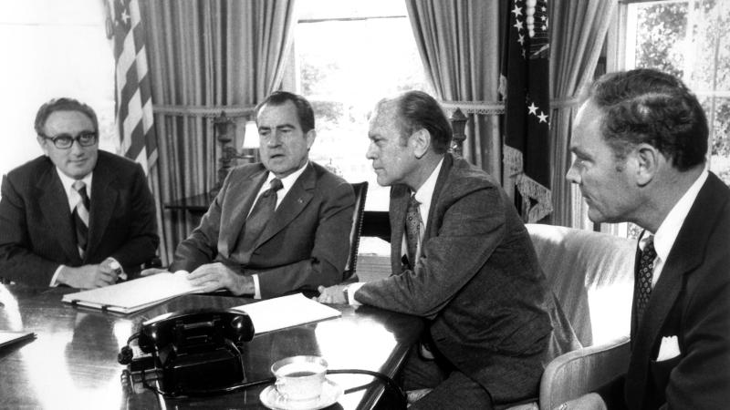 1973 - noch vor seiner Zeit als Außenminister - gelang Kissinger gemeinsam mit dem vietnamesischen Politiker Le Duc Tho ein Waffenstillstand im Vietnamkrieg. Dafür erhielten die beiden im gleichen Jahr den Friedensnobelpreis - im Gegensatz zu Kissinger lehnte Le Duc Tho diesen aber ab. Dem damaligen Außenminister, hier am Tisch mit dem ehemaligen US-Präsidenten Gerald Ford (2.v.r.) und Richard Nixon (2.v.l.), wird vorgeworfen, dass der Vietnamkrieg bei der Verleihung des Nobelpreises noch andauerte. Zur selben Zeit spielte Kissinger eine große Rolle bei den Bemühungen, Frieden zwischen Israel und den arabischen Ländern zu schaffen.