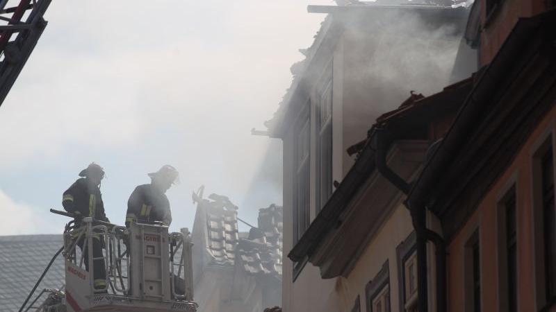 Die Arbeit ging weiter: Feuerwehrleute inspizieren einen ausgebrannten Dachstuhl.