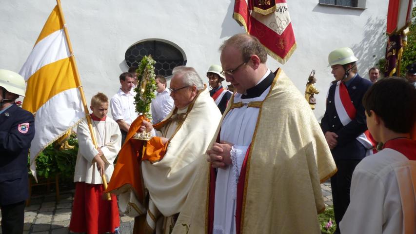 Monsignore Andreas Straub trug die Monstranz mit dem Leib Christi, assistiert vom angehenden Diakon Norbert Förster, durch den Ort, begleitet von der Feuerwehr und zahlreichen Gläubigen.