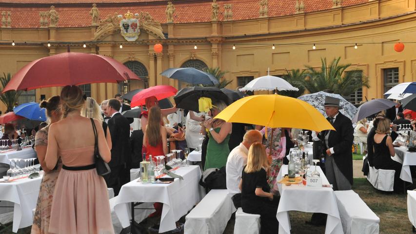 Zu Beginn noch als Sonnenschutz gebrauchte Schirme, wurden später zu Regenschirmen umfunktioniert. Der Großteil der Besucher blieb jedoch.